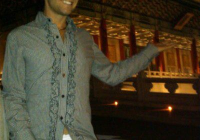 Person posing by illuminated traditional building