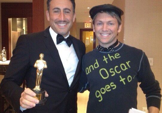 Two men smiling with trophy