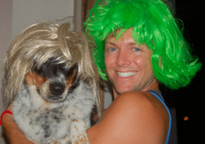 Smiling man and dog in wigs