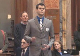 Man in suit giving a speech indoors