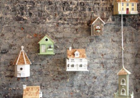 Decorative birdhouses on a brick wall