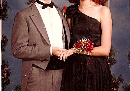Teen couple in formal attire smiling