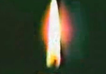 Candle flame glowing in darkness