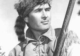 Historical figure holding a rifle outdoors