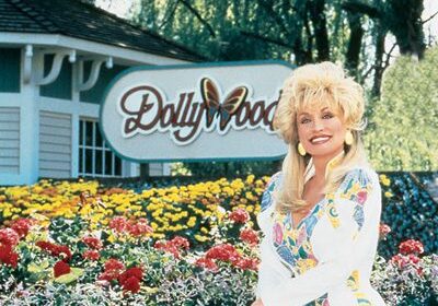 Woman smiling in front of Dollywood sign