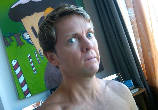 Man with surprised expression by colorful painting