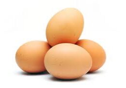 Four brown eggs on white background