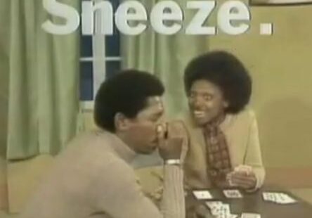 Man sneezing during card game