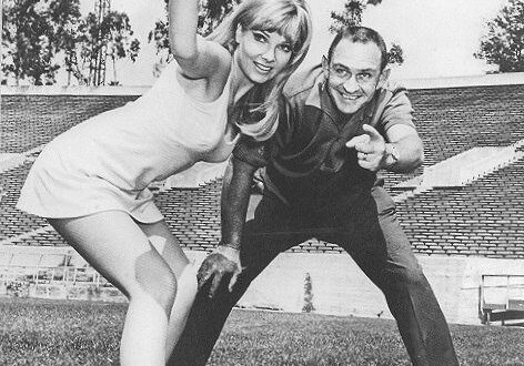 Woman and man playing frisbee in stadium.