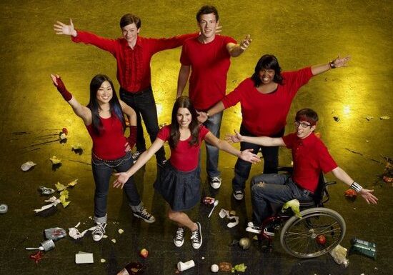 Six people posing on a messy floor