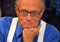 Individual resting chin on hand, wearing glasses