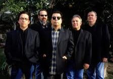 Five men standing outdoors in black jackets