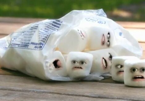 Marshmallows with funny faces on table