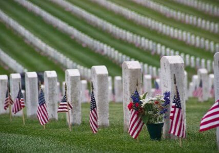 Flags and flowers on cemetery graves
