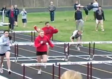Competitors jumping over hurdles in race