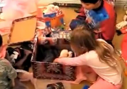 Youngsters exploring holiday gifts eagerly