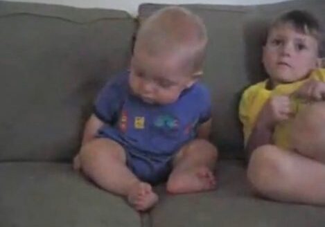 Baby and child sitting on couch