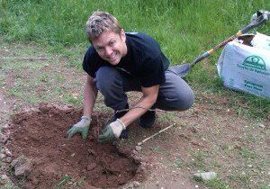 Smiling individual gardening with gloves