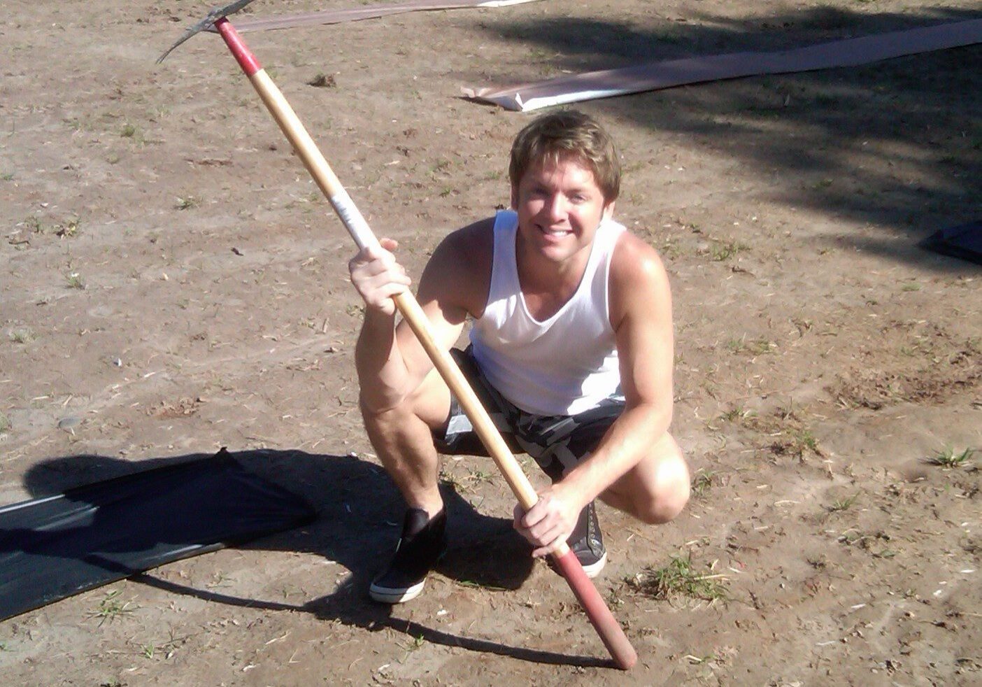 Smiling person with a long-handled tool
