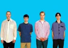 Four people standing against blue background