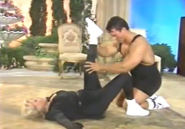 Man assisting woman with leg stretch